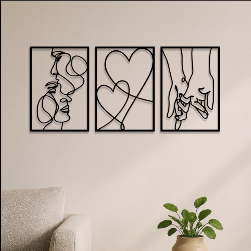 Black metal couples line art set styled above a beige armchair with potted plant