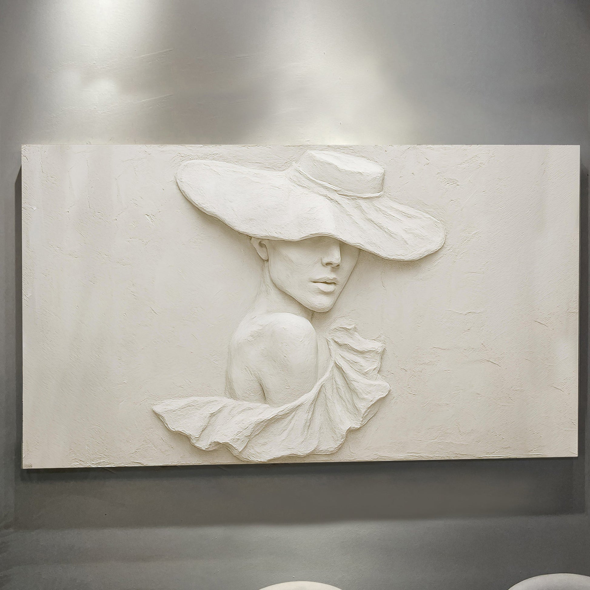 Close-up of the sculptural female portrait with hat in cream tones