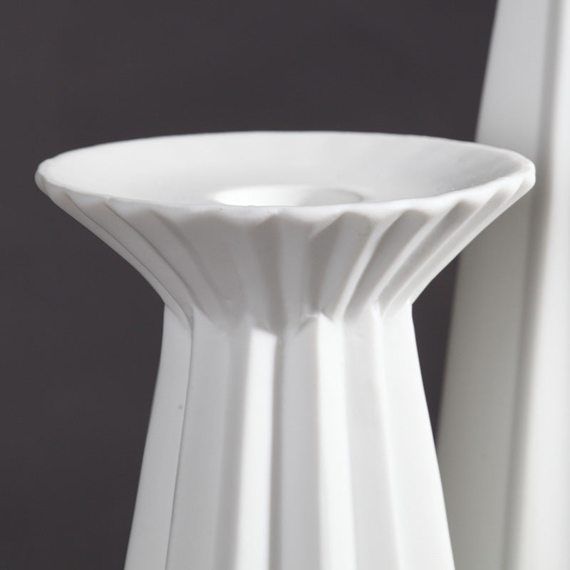 Close-up of the flared, ribbed rim of the white sculptural porcelain candle holder